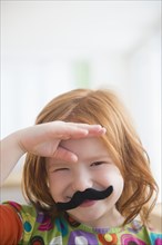 Caucasian girl wearing fake mustache