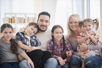 Caucasian parents and children smiling in living room