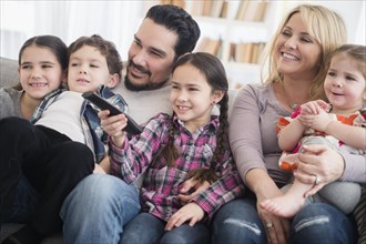Caucasian parents and children smiling in living room