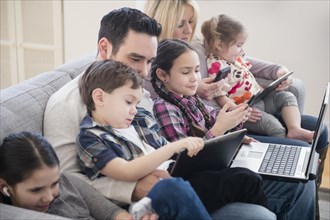 Caucasian family using technology on sofa