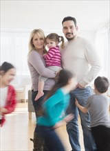 Caucasian parents busy with running children