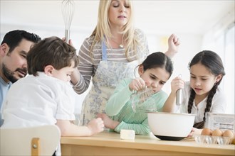 Caucasian parents and children baking in kitchen