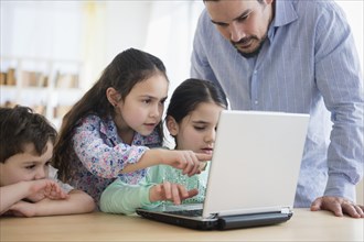Caucasian father and children using laptop