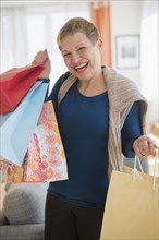 Laughing Caucasian woman holding shopping bags