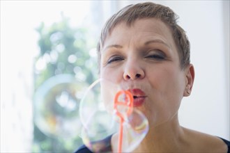 Close up of Caucasian woman blowing bubbles