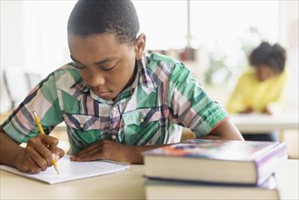 Black student writing in classroom