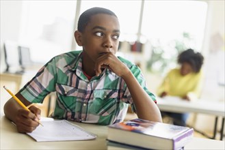 Black student thinking in classroom