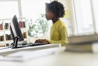 Black student using computer in classroom