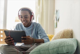 Black boy in headphones using digital tablet
