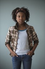 Stylish Black girl standing with hands in pockets