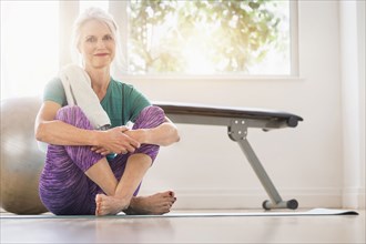 Older Caucasian woman sitting on gym floor