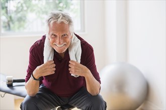 Smiling older Caucasian man resting in gym