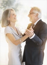 Smiling older Caucasian couple dancing