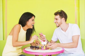 Hispanic couple sharing ice cream sundae