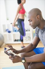 Man using digital tablet in gym