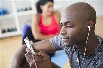 Man listening to earphones in gym