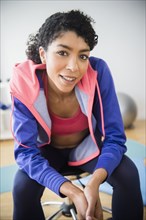 Mixed race woman sitting in gym
