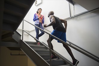 Man running with trainer on staircase
