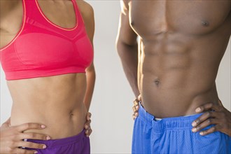 Close up of abdominals of athletic couple wearing sportswear