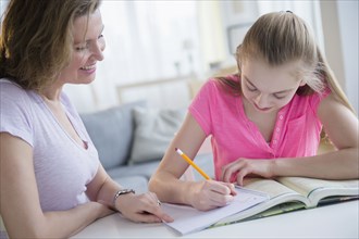 Caucasian mother helping daughter with homework