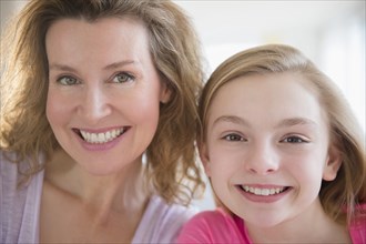 Close up of Caucasian mother and daughter smiling