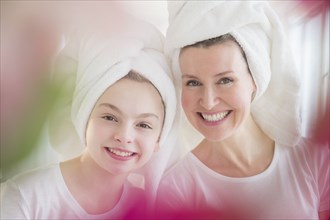 Caucasian mother and daughter wearing towels in hair