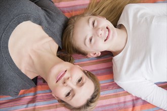 Caucasian mother and daughter laying on blanket