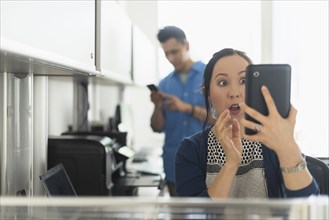 Surprised businesswoman using digital tablet in office