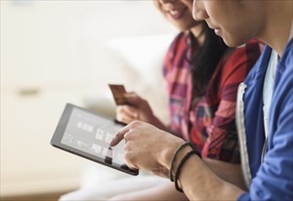Close up of couple shopping online on digital tablet