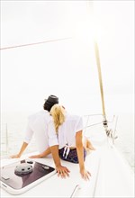 Couple cuddling on deck of sailboat