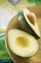 Close up of halved avocado in bowl