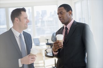 Businessmen drinking coffee in office