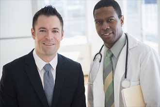 Businessman and doctor smiling in office