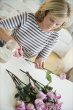 Caucasian woman trimming flowers