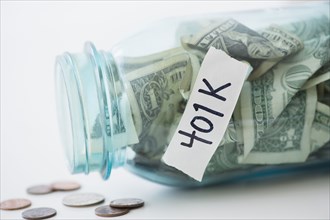 Close up of spilling 401K savings jar