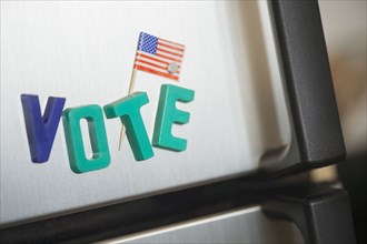 Close up of vote magnets and American flag on refrigerator