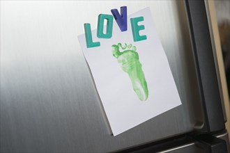 Close up of love magnets and footprint on refrigerator