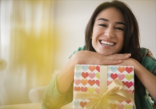 Close up of woman leaning on wrapped gift