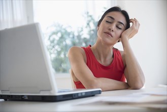 Stressed businesswoman sitting at laptop at desk