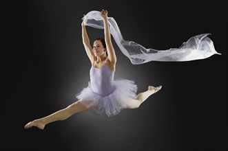 Hispanic ballet dancer leaping in mid-air