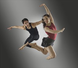 Hispanic dancers leaping in mid-air