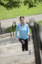 Hispanic woman jogging on city steps