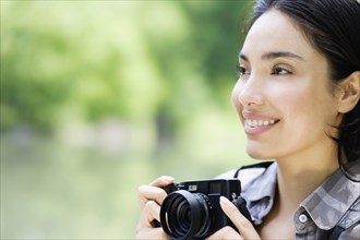 Hispanic woman photographing outdoors