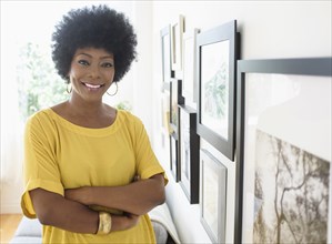African American woman standing near pictures on wall