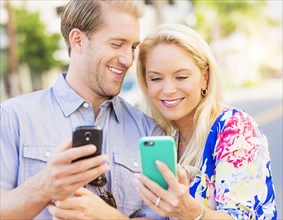 Caucasian couple using cell phones
