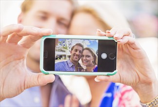 Caucasian couple taking selfie on cell phone