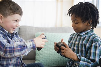 Boys playing video games on sofa