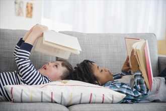 Boys reading on living room sofa