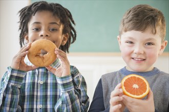 Students eating donut and orange in classroom
