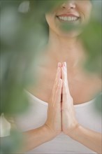 Mixed race woman meditating with clasped hands